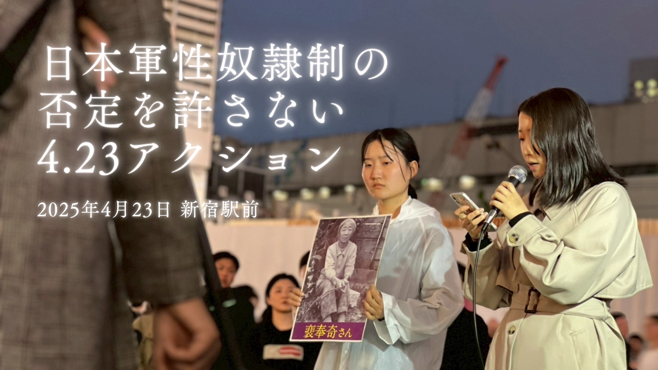 2025年4月23日、夕方の新宿駅前で行われた「日本軍性奴隷制の否定を許さない 4.23アクション」の様子。 白いレインコート姿の人が、日本軍性奴隷制サバイバー・裴奉奇（ペ・ポンギ）さんの写真を掲げ、 隣でマイクを手に証言を朗読している。背景には街の灯りとクレーンが見える。 画面左には別の参加者の姿も映り、緊張感と静かな決意が伝わる。